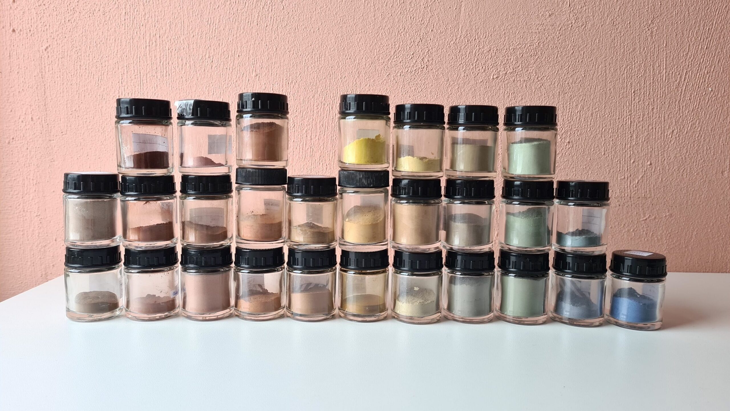 Een verzameling van potjes gevuld met mijn pigmenten. We beginnen links met de bruin tinten, overgaand richting rechts naar rood, geel, groen en blauw.